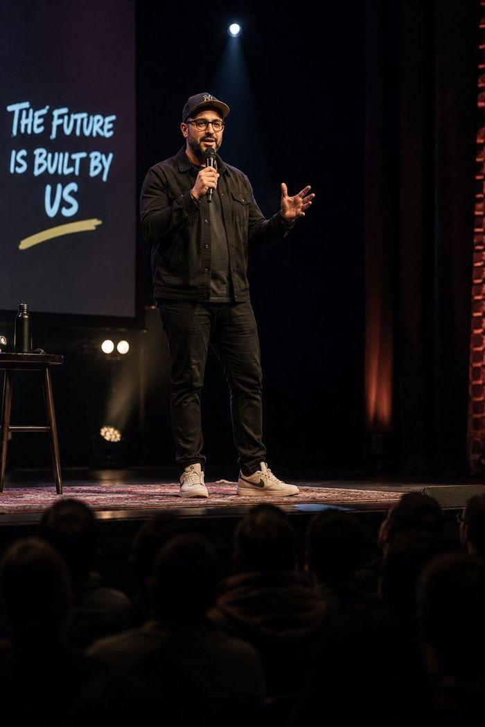 A speaker on stage before a full audience
